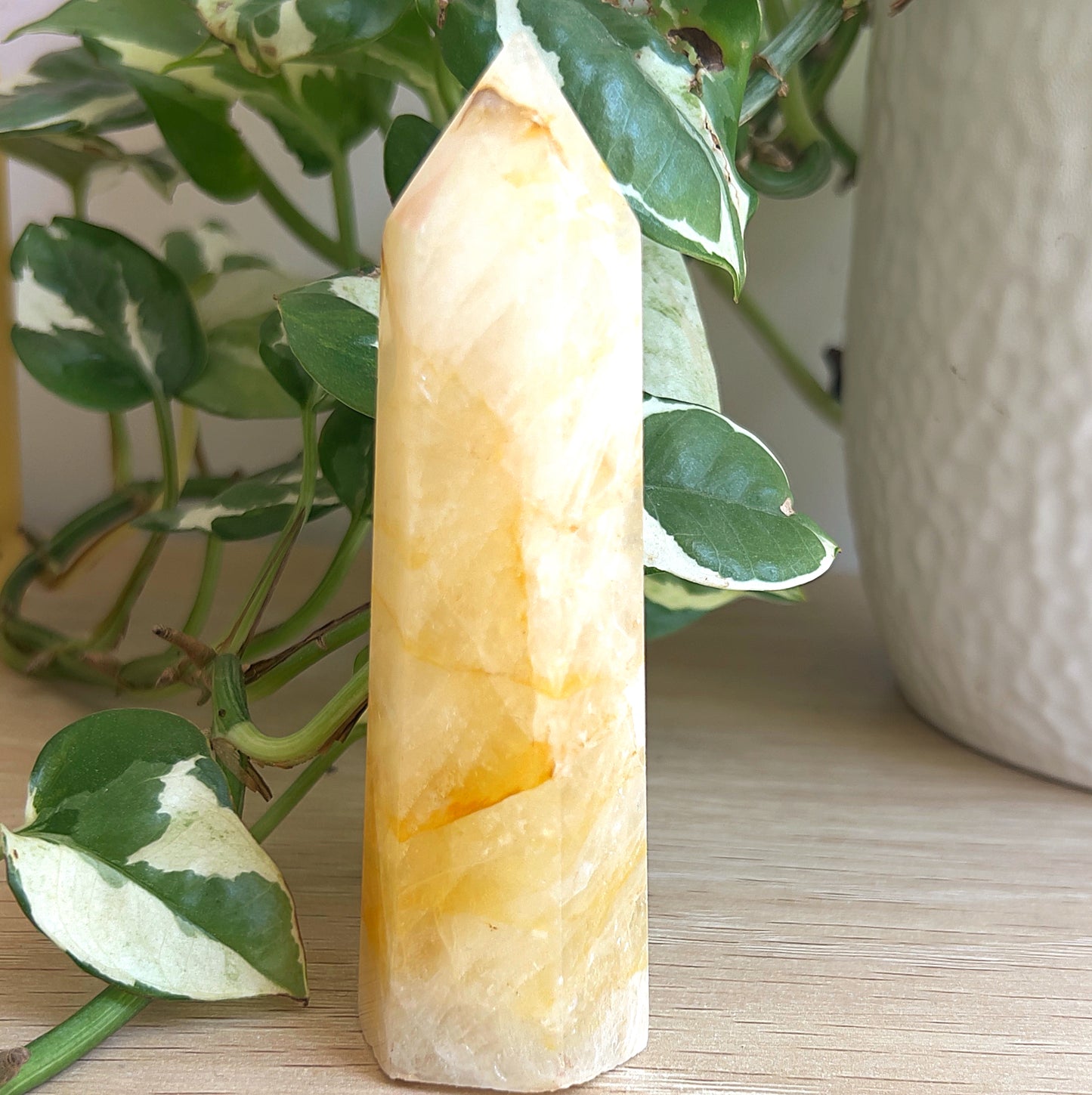 Golden Healer tower on a wooden surface with green leaves in the background