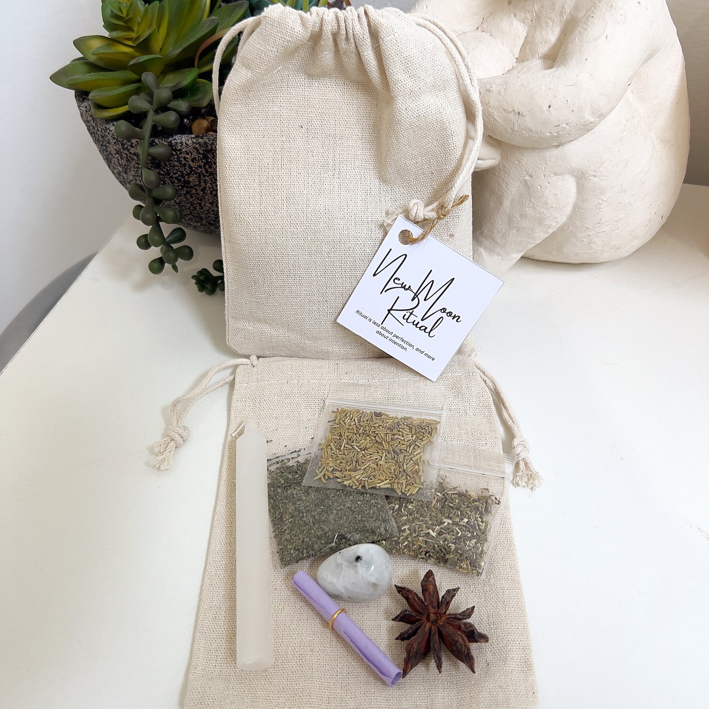 Ritual pack on packaging with drawstring bag, ritual herbs, and decorative elements on a white surface.