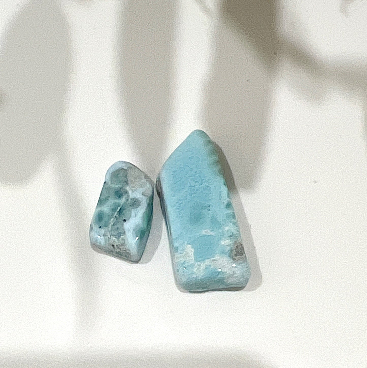 Two free-form Larimar stones on neutral background | Simply Esoteric