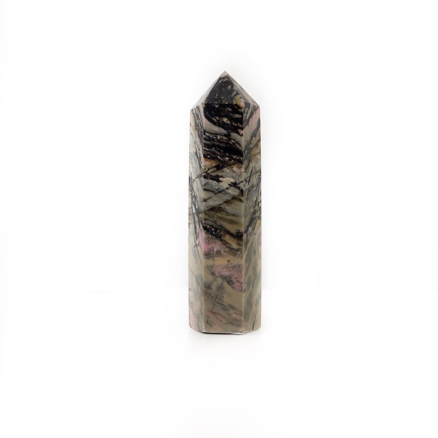 A striking rhodonite tower, standing tall with a tapering shape and a polished surface. It features a rich tapestry of pinks, blacks, and creams, with intricate banding and web-like patterns throughout. The stone’s pointed top and sleek edges give it a commanding presence, set against a clean, white background that contrasts with the stone's bold, natural colors. | Simply Esoteric
