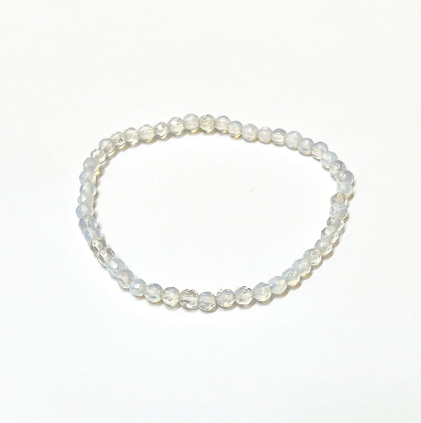 An Opalite bead bracelet with sparkling 4mm faceted beads, exhibiting a milky translucence with soft iridescent hues, on an 18cm stretchy cord, radiating a gentle yet powerful energy. | Simply Esoteric