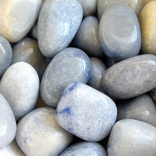 A smooth, polished Blue Quartz Tumbled Stone with serene blue hues, symbolizing calm, creativity, and clear communication, perfect for fostering tranquility and self-expression | Simply Esoteric