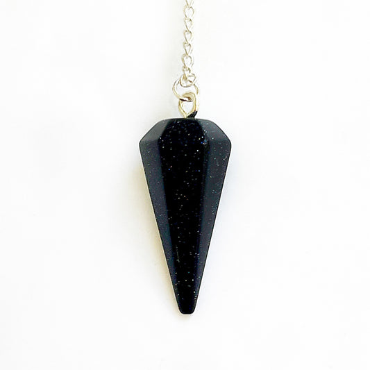 A Blue Goldstone pendulum, resembling a starry night sky with sparkling copper flecks against a deep blue background, symbolizing ambition, confidence, and the cosmic energy guiding towards goals, suspended on a sleek chain. | Simply Esoteric