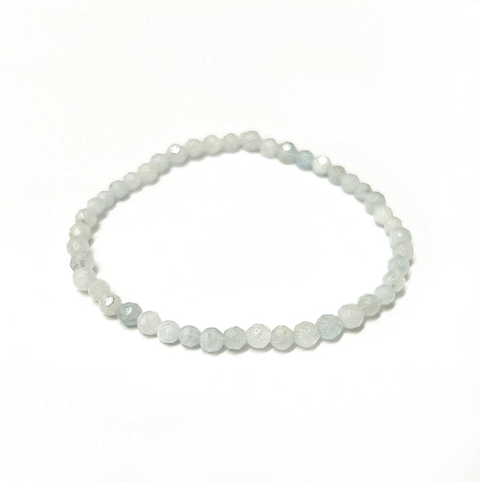 An elegant aquamarine bead bracelet with 4mm faceted beads showcasing shades of tranquil sea blue, strung on an 18cm stretchy cord, embodying the calming essence of the ocean. | Simply Esoteric