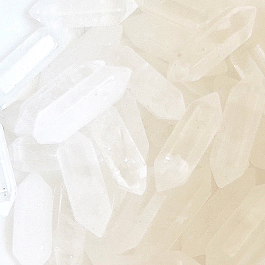 A collection of small clear quartz double terminated points, each crystal clear and polished, showcasing sharp, symmetrical ends that enhance energy flow in both directions, ideal for spiritual alignment and energy balancing. | Simply Esoteric