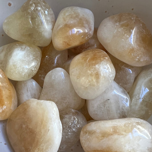 Citrine tumbled stones, polished to a smooth finish, showcasing radiant shades of golden yellow. These stones are known for attracting prosperity, boosting self-esteem, and enhancing creativity, making them ideal for personal and financial growth. | Simply Esoteric