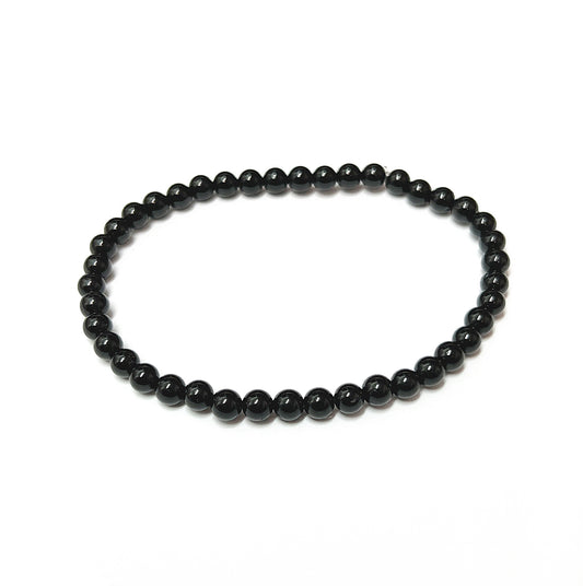 A sleek black tourmaline bead bracelet with uniform 4mm beads, known for protective qualities, on an 18cm stretch cord for a comfortable fit and easy daily wear. | Simply Esoteric
