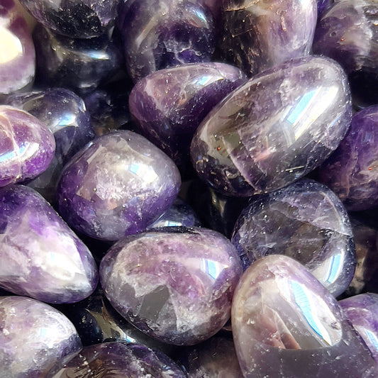 Chevron Amethyst tumbled stones showcasing distinctive V-shaped white and deep purple patterns, polished to a smooth finish. These stones are ideal for enhancing spiritual growth, providing psychic protection, and promoting peace. | Simply Esoteric