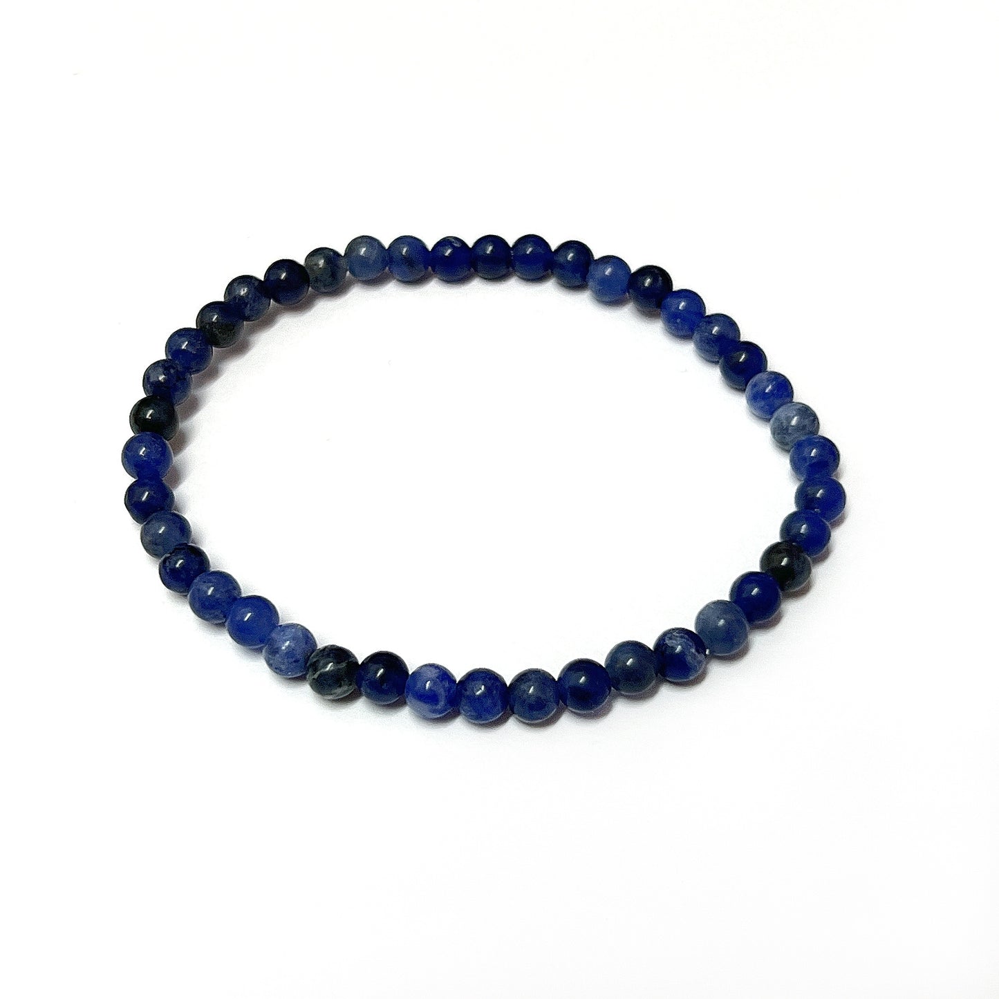 A Sodalite bead bracelet with rich royal blue 4mm beads interlaced with white patterns, strung on an 18cm stretch cord, capturing the essence of a starry night sky. | Simply Esoteric