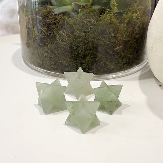 Green Aventurine Merkaba Stars, approximately 2.5cm each, placed in front of a vibrant arrangement of green succulents. | Simply Esoteric